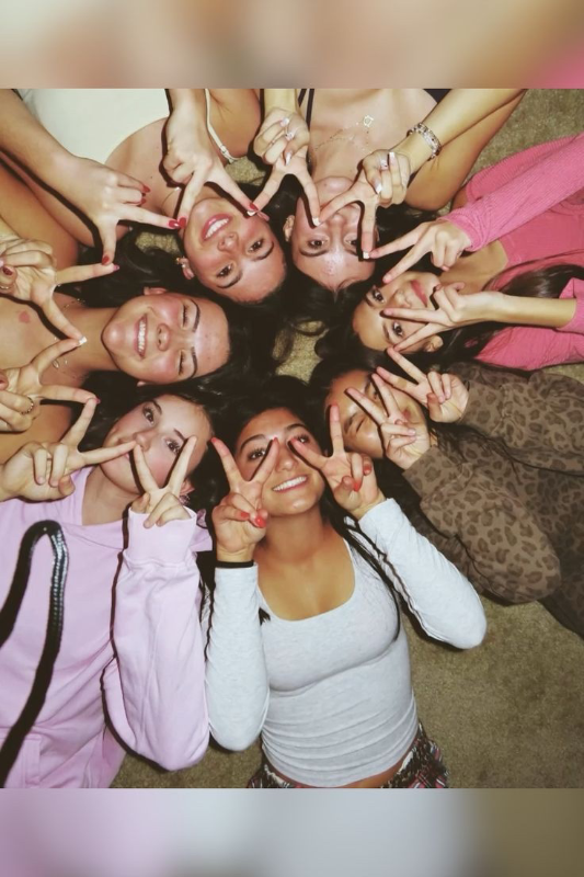 A circle of teen girls making peace signs